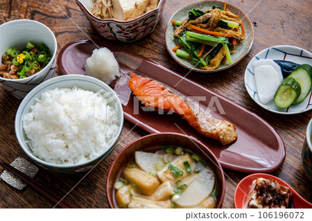 Homely Japanese set meal of grilled salmon (rice, miso soup, natto, pickles, cold tofu, small bowl) 106196072