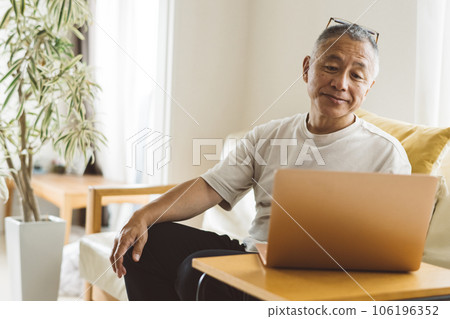 Senior men operating a computer 106196352