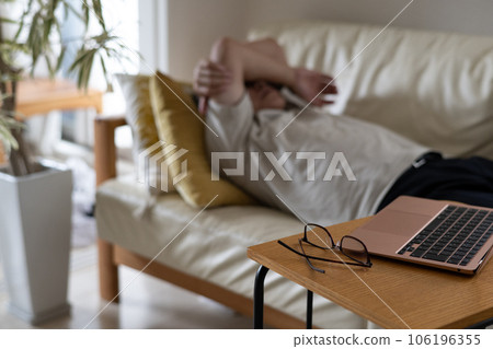 一個因遠程工作而犯困並睡在沙發上的男人 一個因遠程工作而犯困並睡在沙發上的男人 106196355