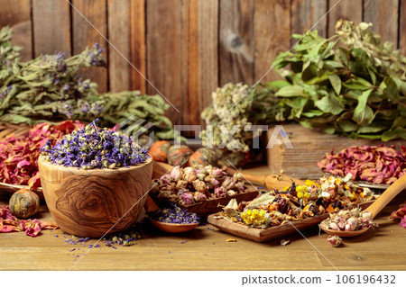 Various dried medicinal plants, herbs, and flowers on an old wooden background. 106196432