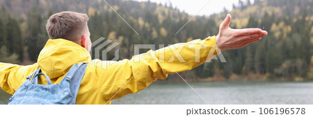 Male traveler with backpack is happy to see his travel destination - lake and mountains. 106196578