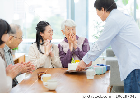 Three generation family celebrating grandmother 106197043