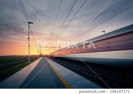 Long exposure of train on railroad track at sunrise. Long exposure of train on railroad track at sunrise. 106197171