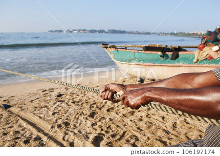 Strong hands during pulling rope with fishing net. Strong hands during pulling rope with fishing net. 106197174