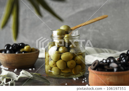 Olives in bowls and jar on gray background 106197351