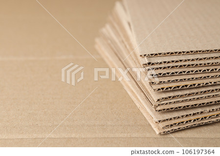 Corrugated cardboard on the table is laid out in layers. 106197364