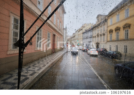 Raindrops on window of tram in city street. Raindrops on window of tram in city street. 106197616