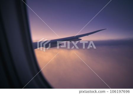 View from window of airplane during flight above clouds 106197696
