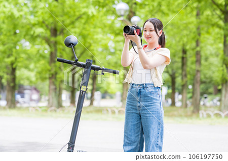 A young and cute woman who takes a hobby camera while moving on an electric kickboard | Image of a camera girl A young and cute woman who takes a hobby camera while moving on an electric kickboard | Image of a camera girl 106197750