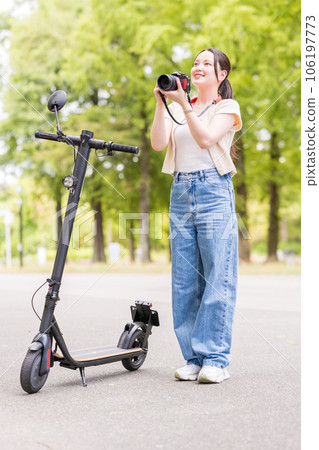 A young and cute woman who takes a hobby camera while moving on an electric kickboard | Image of a camera girl A young and cute woman who takes a hobby camera while moving on an electric kickboard | Image of a camera girl 106197773
