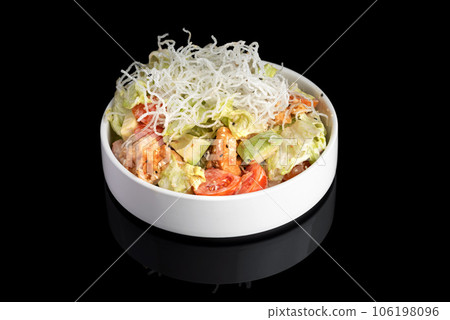 Puff salad with shrimp, avocado and tomato, seasoned with yogurt sauce on plate. restaurant dish on a black background with reflection. 106198096
