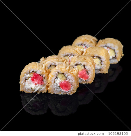 Fried sushi roll on a dark background. Restaurant with Japanese cuisine. Fried sushi roll on a dark background. Restaurant with Japanese cuisine. 106198103