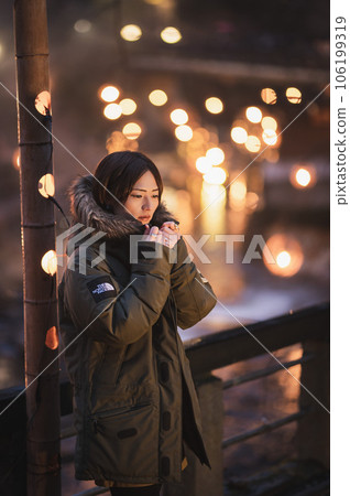 一個女人在竹燈籠前看起來很冷，背景是熱水 106199319