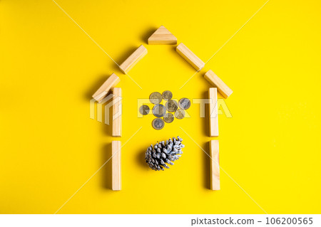 Wooden house model with coins, money, copy space on yellow background. 106200565