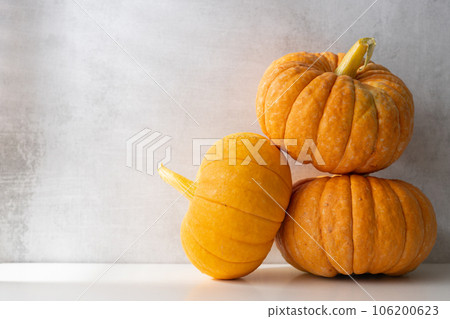 three whole ripe pumpkins on a light background. Autumn harvest 106200623