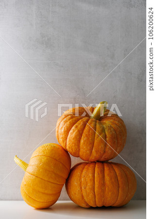 three whole ripe pumpkins on a light background. Autumn harvest 106200624