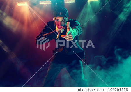 Emotional concert. Young artistic people, men, musicians making creative, loud performance over neon illumination 106201318