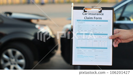Close up of a man car insurance agent inspecting damaged car with insurance claim form. Insurance concept. 106201427