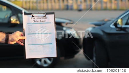 Close up of a man car insurance agent inspecting damaged car with insurance claim form. Insurance concept. 106201428