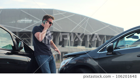 Car accident with wrecked car and man on phone. Man calling to report car accident. Road safety and insurance concept. 106201648