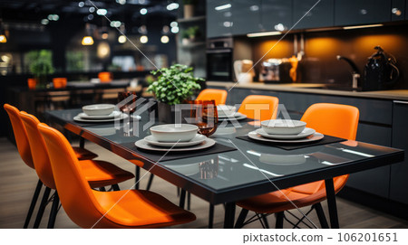 A large table for 6 person with bright orange chairs against the backdrop of a glossy kitchen 106201651