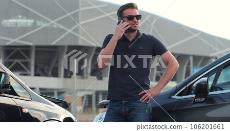 Car accident with wrecked car and man on phone. Man calling to report car accident. Road safety and insurance concept. Car accident with wrecked car and man on phone. Man calling to report car accident. Road safety and insurance concept. 106201661