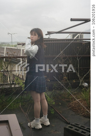 A woman standing on the roof of a school on a rainy day A woman standing on the roof of a school on a rainy day 106201916