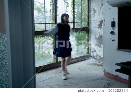 A high school girl dancing in front of a large window at school A high school girl dancing in front of a large window at school 106202224