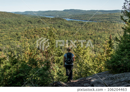 Girl hiking in the Forest near lake in La Mauricie National Park Quebec, Canada on a beautiful day 106204463