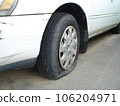 Punctured tire and scratches on the body of a white car, close up. 106204971