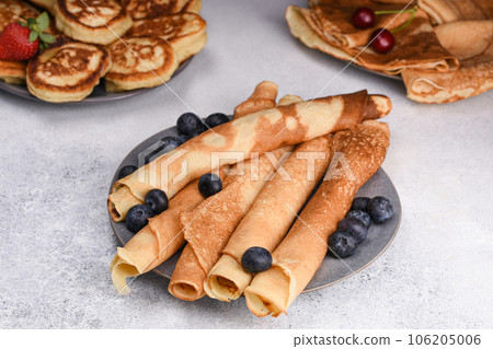 Variety of pancakes with berries, honey and jam. Different kind of pancakes. Traditional and tiny, crepe and old fashioned pancakes. Festive brunch set. Variety of pancakes with berries, honey and jam. Different kind of pancakes. Traditional and tiny, crepe and old fashioned pancakes. Festive brunch set. 106205006
