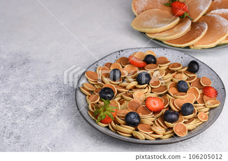 Tiny pancake cereal With Strawberries And Blueberries for breakfast. Food Background. 106205012