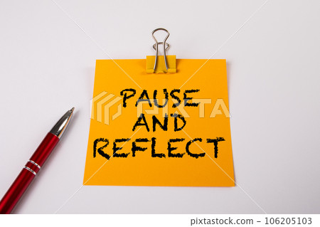PAUSE AND REFLECT. Yellow notepad with text on a white background PAUSE AND REFLECT. Yellow notepad with text on a white background 106205103