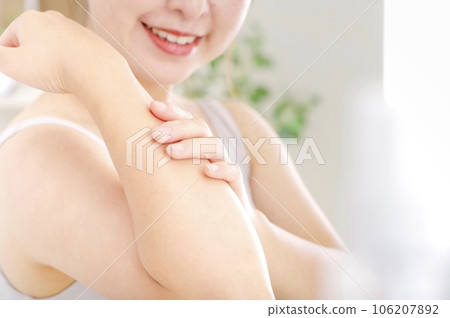 young woman touching her arm 106207892