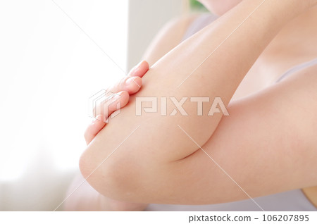 年輕女子撫摸她的手臂 年輕女子撫摸她的手臂 106207895