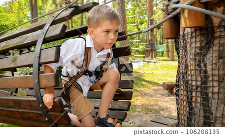 Little boy crawling through tube obstacle in rope adventure park Little boy crawling through tube obstacle in rope adventure park 106208135