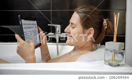 Woman Combines Bath Time with Tablet Computer. Working at home, modern technology, remote job 106209564