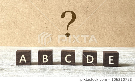 五個帶有 ABCDE 字母和問號的棕色立方體_軟木塞背景 106210758