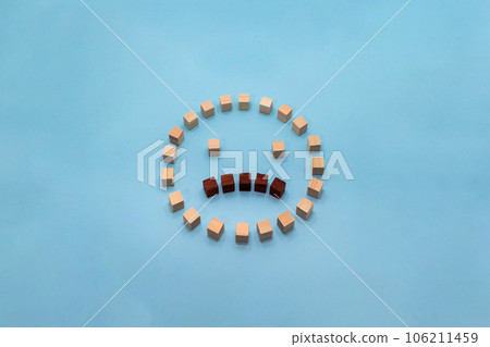 Three-dimensional round icon with a troubled expression made by arranging wood cubes 106211459