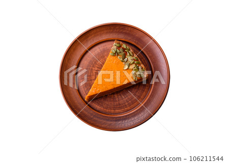 Beautiful tasty pumpkin pie with slices on a black ceramic plate Beautiful tasty pumpkin pie with slices on a black ceramic plate 106211544