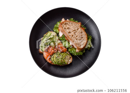 Fresh tasty sandwich with salmon, avocado and sesame and flax seeds Fresh tasty sandwich with salmon, avocado and sesame and flax seeds 106211556