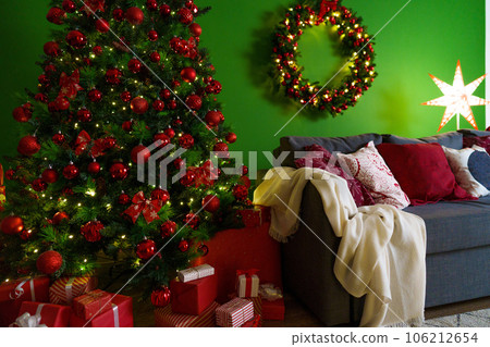 Christmas living room interior with sofa, Christmas tree and wreath on green background Christmas living room interior with sofa, Christmas tree and wreath on green background 106212654