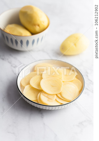 Potato and potato chips placed on a marble slab. 106212902