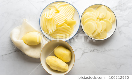 Potato and potato chips placed on a marble slab. Potato and potato chips placed on a marble slab. 106212950
