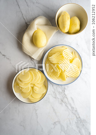 Potato and potato chips placed on a marble slab. Potato and potato chips placed on a marble slab. 106212952