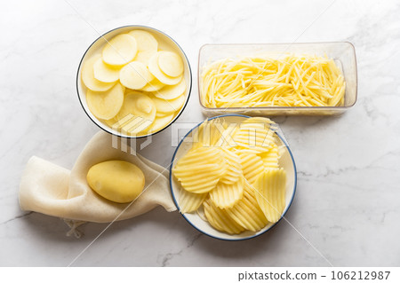 Potato, shredded potato, and potato chips placed on a marble slab. Potato, shredded potato, and potato chips placed on a marble slab. 106212987