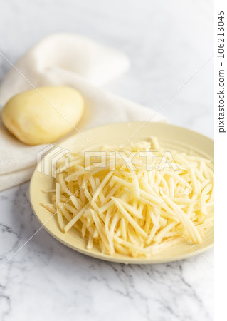 Potato and shredded potato placed on a marble slab. Potato and shredded potato placed on a marble slab. 106213045