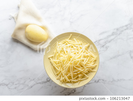Potato and shredded potato placed on a marble slab. 106213047