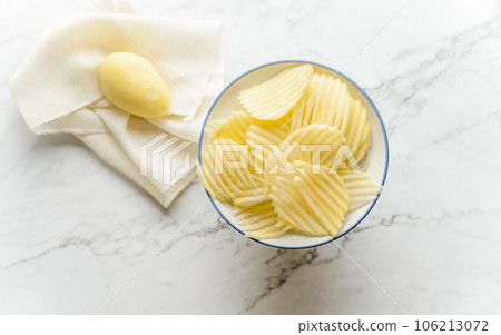 Potato and potato chips placed on a marble slab. 106213072