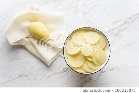Potato and potato chips placed on a marble slab. 106213073